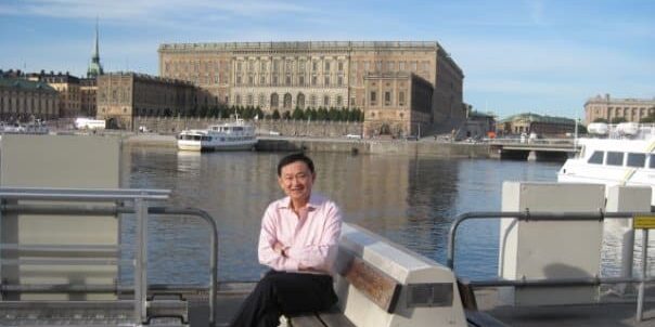 thaksin infront of the royal palace stockholm Former Thai prime minister Thaksin Shinawatra sitting on a waterfront bench in front of the Royal Palace in Stockholm.