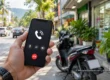 Hand holding a mobile phone with a generic call screen on a Thai street near a parked scooter. AI-generated illustration.