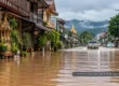AI-generated illustrative scene of floodwater covering a road in a northern Thai town, representing travel disruption and flood safety.