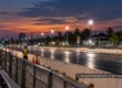 Empty drag racing track with barriers and a safety marshal at dusk.