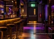 Empty nightclub with a clear emergency exit and a fire extinguisher.