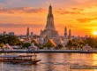 Wat Arun temple across the Chao Phraya River in Bangkok at sunset, with a river boat passing. AI-generated image.